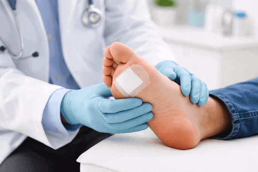 doctor examining a bandaged foot ulcer in clinic