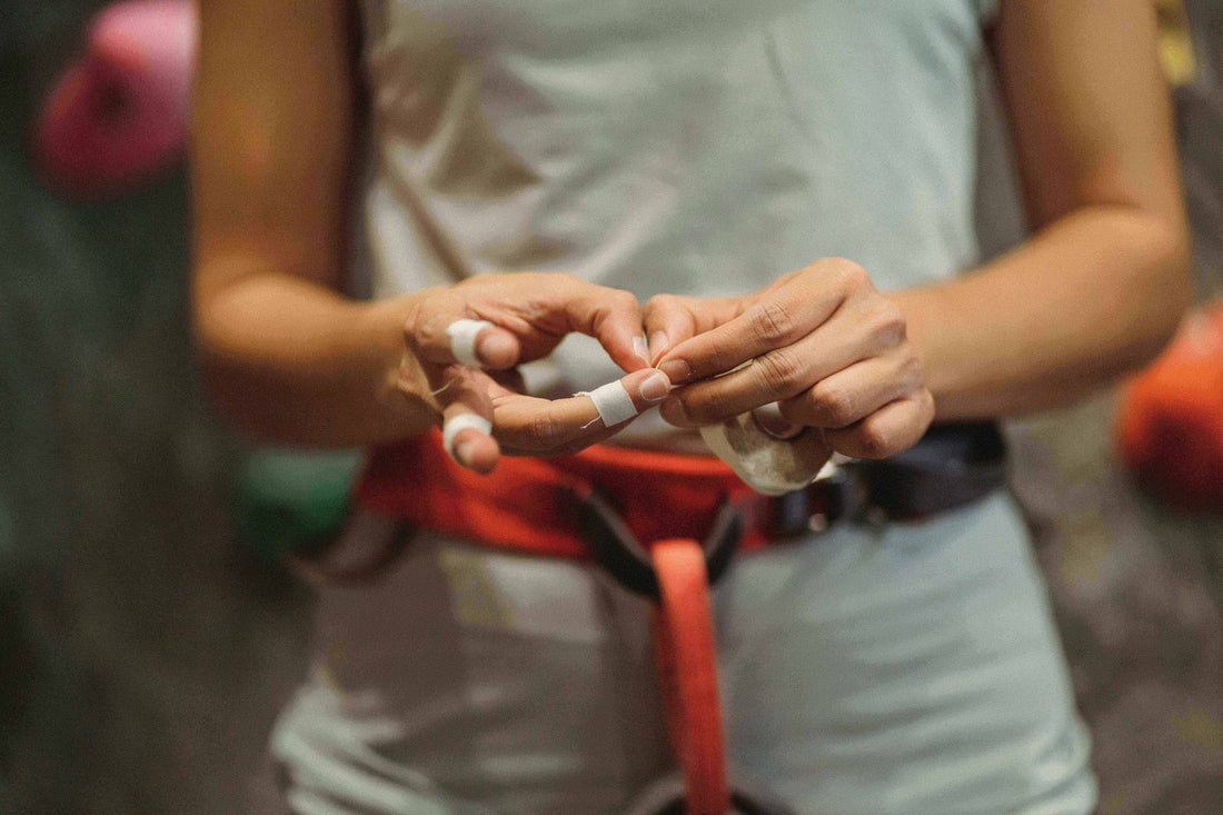rock climber taping fingers before climbing session