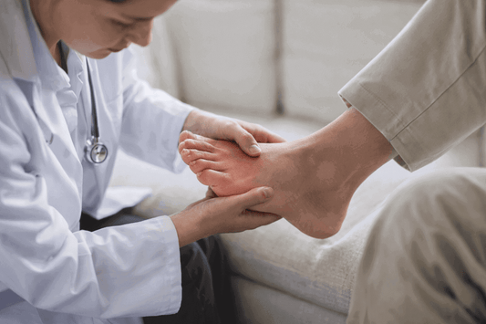 doctor gently examining a red, swollen foot for signs of infection